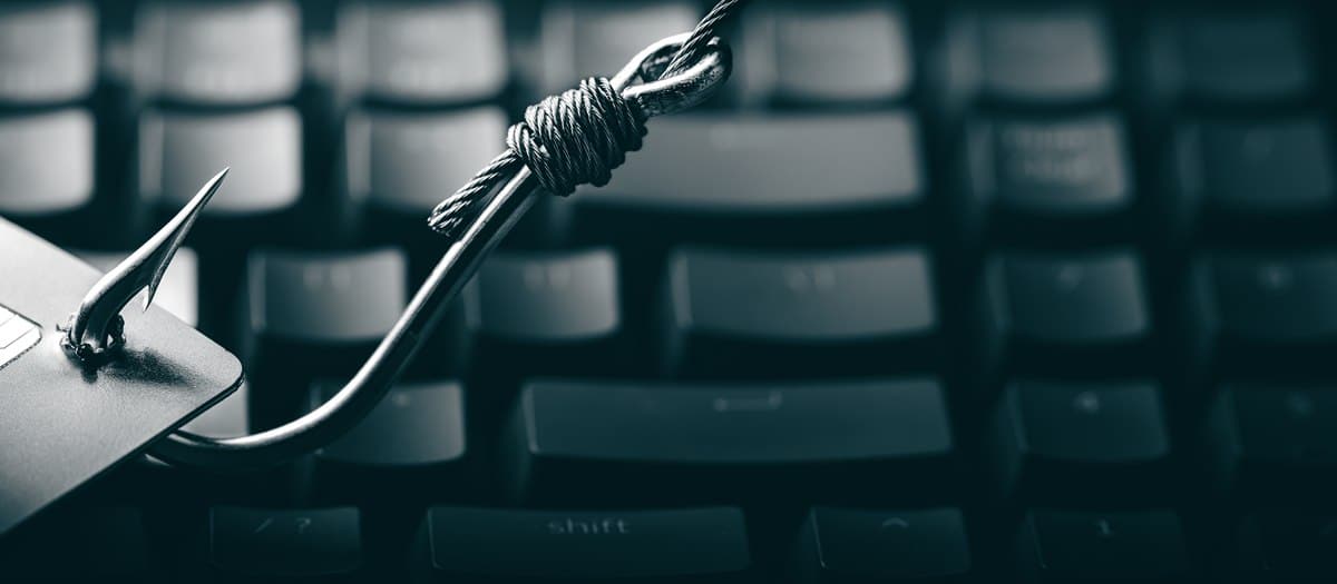 Noose tied with rope draped over a laptop keyboard, suggesting self-harm risk.